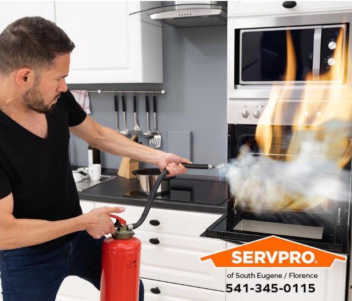 A person uses a fire extinguisher to put out an oven fire.